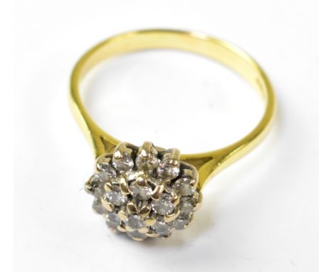 An 18ct gold diamond cluster ring, the head comprising nineteen small claw set diamonds over three levels, on an 18ct gold sh