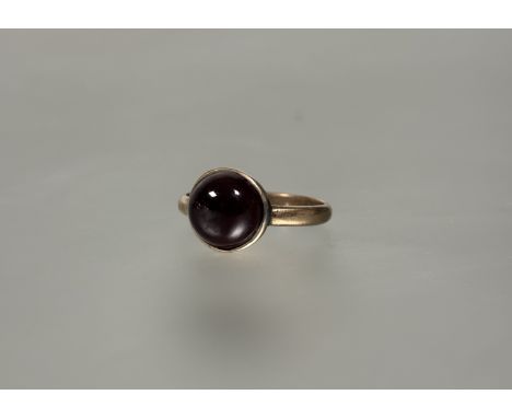 A 9ct gold garnet cabouchon ring in rub over setting approximately 4ct T 3.22g