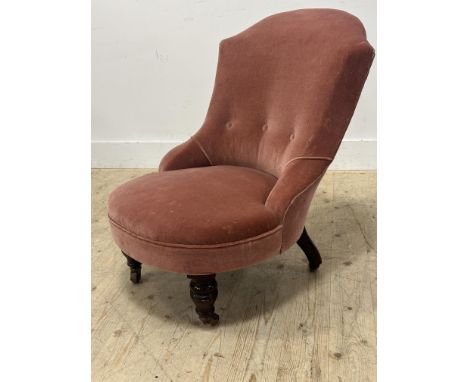 A Victorian walnut button back bedroom chair in pink plush fabric, with brass caps and china castors (h.74cm x l. 59cm x w.70