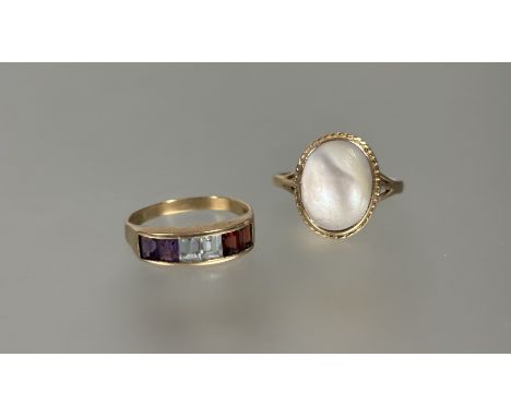 A 9ct gold ring set oval mother of pearl in rope pattern border L x 1.5cm R/S 2.79g and a 9ct gold ring set two central clear