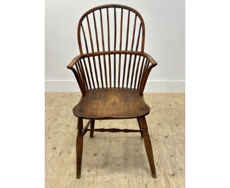 An early 19thc yew wood comb back kitchen chair, with elm saddle seat on turned baluster supports united by stretcher (h. 104