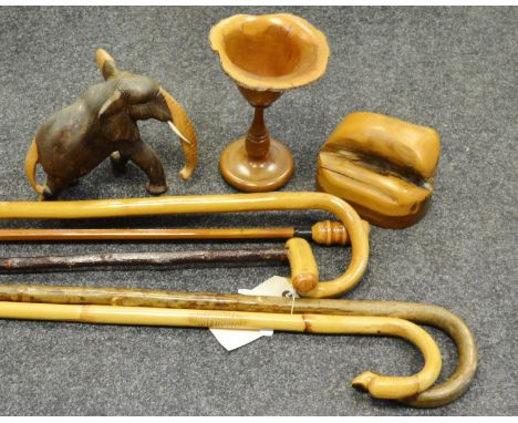 Walking sticks - two crooks; an market stick; a walking pole; another;treen; a wooden goblet; a pot and cover; an elephant (6