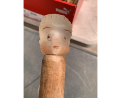 A WOODEN WALKING STICK WITH A GLASS HEAD OF A CHILD 