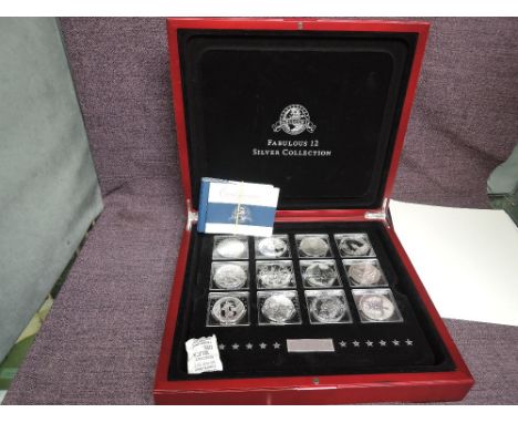 The 2011 Fabulous 12 Silver Coin Collection in wood case with certificates, Silver Proof Crown sized from around the world in