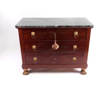 An early 19th century French Empire marble-topped mahogany commode, the three long drawers with gilt lion's mask and ring han