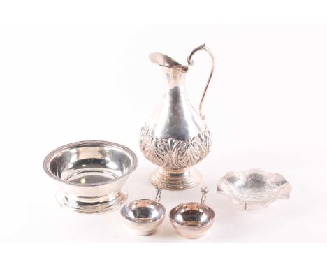 An early 20th century (800) silver baluster ewer, (24 cm high) with repoussé decorated body, two (800) shallow cups with wing