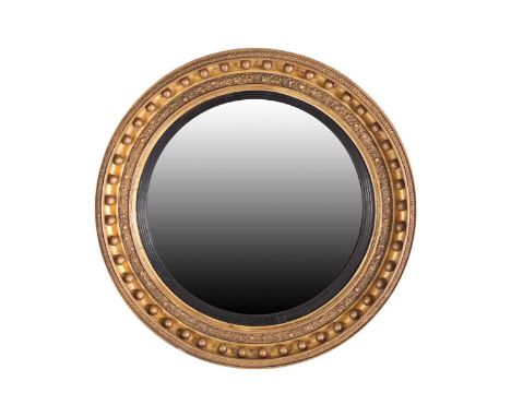 A large and impressive Regency circular carved wood and gilt gesso convex wall mirror. The moulded frame with applied spheres