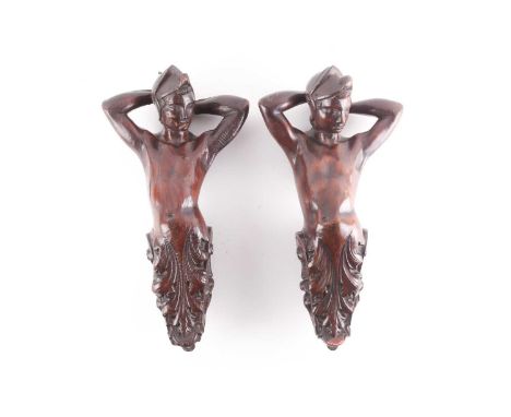 Two late 19th century carved oak architectural atlantes, modelled with their arms resting behind their heads, with leaf and s