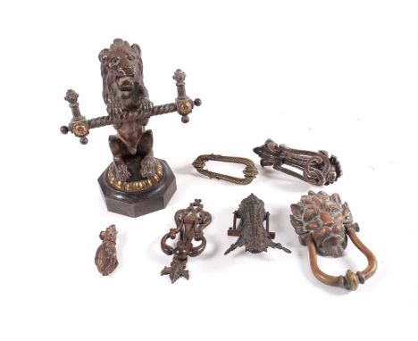 A collection of 19th-century metalware door knockers, to include a large lion-mask example, and a cast-iron lion fire dog, 27