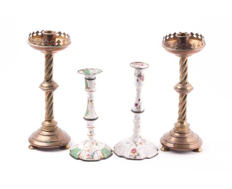 A pair of 19th-century brass candlesticks, in the Gothic Revival taste, 33 cm high, together with two Bilston enamel candlest