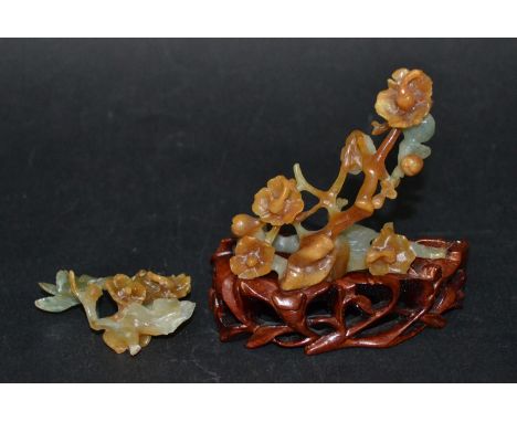 Chinese russet and celadon green jade carved flowering bush with a bat and a bird on a branch, height 3", upon carved wood fi