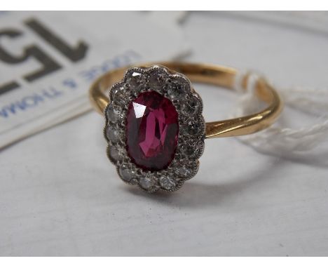 18ct diamond and ruby cluster ring, the oval 5mm x 7mm ruby surrounded by fourteen small diamonds, 2.9 grams approx.