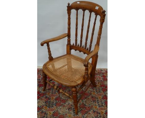 Victorian mahogany gothic influenced armchair, the top rail with C-scroll carving over the turned stick back, outswept arms w