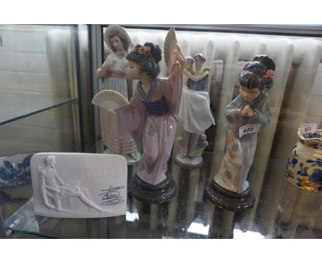 Three Lladro and one Nao figurines to include Japanese Gaisha girls, also a Lladro collectors society plaque.