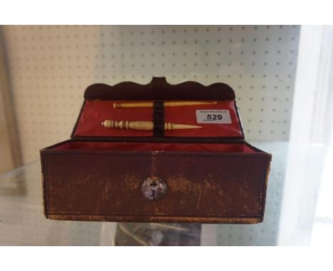 A Victorian leatherette travelling sewing case Enclosing a horn button hook and ivory needle holder, length 18cm.