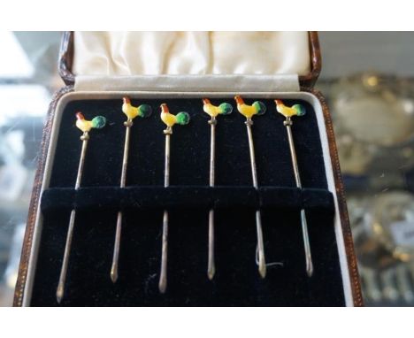 A set of six sterling silver and enamel cocktail sticks with cockerel finials.