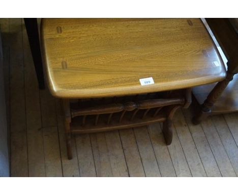 An Ercol medium elm coffee table/magazine rack having twin division magazine holder.