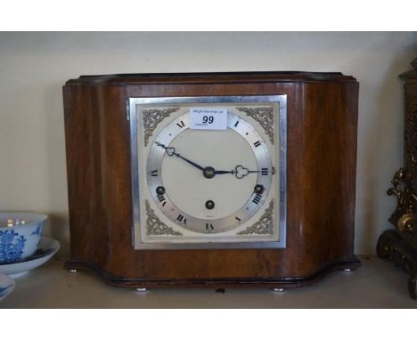 An Art Deco Elliott walnut serpentine fronted mantel clock.