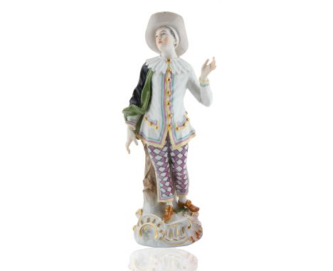 on a gilt-edged, scroll moulded base with applied flowers, wearing a multi-colored shirt and pantaloons, black and green cape