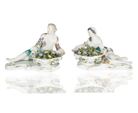 modelled as reclining man and woman, each holding reticulated floral encrusted baskets filled with applied flowers on a c-scr