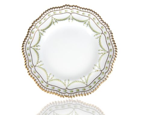 circular with a gilt rim, the cavetto with a garland swag of bay leaves against a stark white ground, marked with factory mar