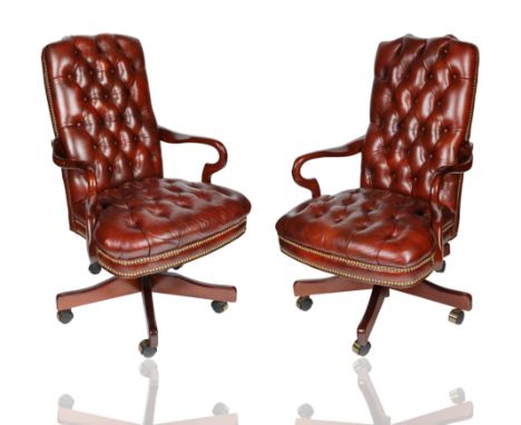 each atop four castor wheels with mahogany stained and polished frames, with tufted faux leather upholstery with brass nails;