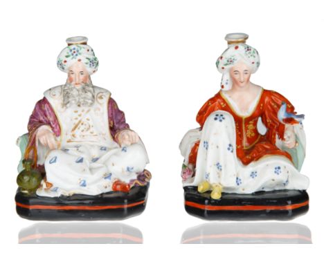 modelled after Jacob Petit, formed as a pair of seated figures atop a black and red square base with rounded edges, dressed i