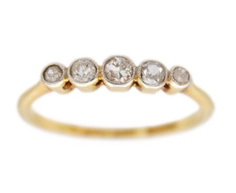An 18ct gold and platinum diamond five stone ring. The small graduated old round cut diamonds in a millegrain setting, stampe