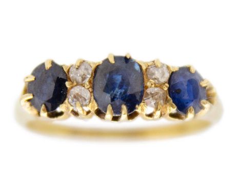 An Edwardian 18ct hallmarked gold diamond and sapphire set ring. Set with three oval cut blue sapphires, the principle stone 