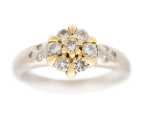 An 18ct yellow and white gold diamond set cluster ring. The seven round brilliant cut diamonds each of 0.07ct estimated weigh