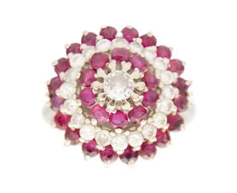 An 18ct white gold ruby and diamond set cluster target ring. The central principle diamond of 0.15ct approxmate weight, head 