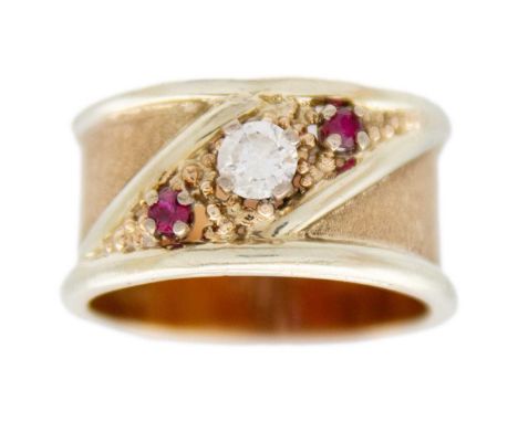 A high purity gold (tests 14ct) wide band ring with central CZ and two red spinels The ring is in size O, 6g in weight.