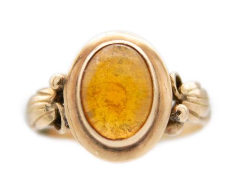 A rose gold fire opal set ring. The oval cabochon opal showing green, orange, yellow and red colours, leaf and berry design a