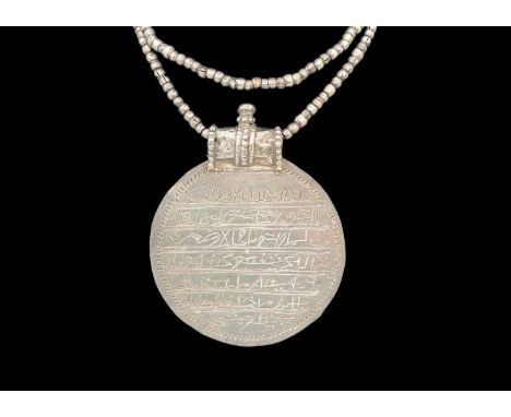 An Omani silver circular amulet/necklace. With inscriptions, diameter 7.8cm.