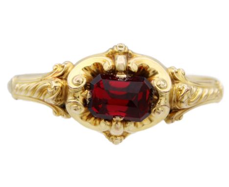 A Victorian high-purity gold (tests 14ct) bangle with large red paste stone. Of hollow scroll embossed design and adjustable 