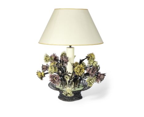 A mid-20th century continental tole dahlia lamp formed as a basket of flowersWith a central column support and card shade 84c