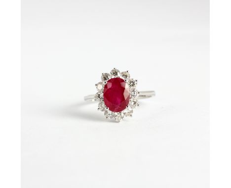 An 18ct white gold (stamped 750) cluster ring set with an oval cut ruby and brilliant cut diamonds, approx. 2.6ct ruby, 1.01c