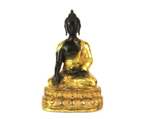 A Tibetan gilt bronze figure of a seated Buddha, H. 23cm.