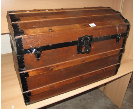 Canvas, dome topped trunk with wooden and metal banding and metal carrying handles.
