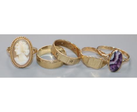A 9ct gold wedding band and four other rings, including a 9ct gold gypsy-set ring (a.f.), a 9ct gold and amethyst ring, a yel