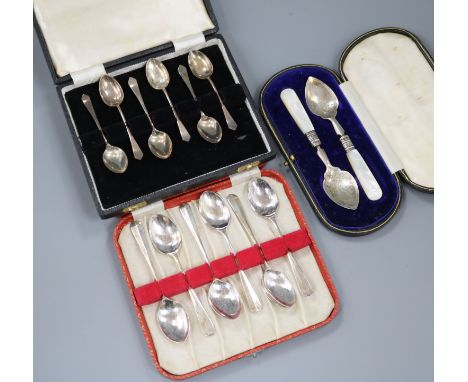 Two cased sets of silver coffee spoons and a cased pair of silver and mother of pearl butter? servers.