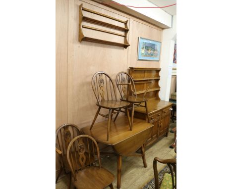 An Ercol six piece dining room suite consisting of four chairs, a drop leaf table, a sideboard and a plate rack sideboard W.1