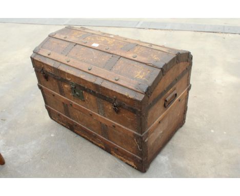 AN EDWARDIAN COMPRESSED FIBRE DOMED TOP TRAVELLING TRUNK WITH METAL FITTINGS AND WOODEN SLATS 