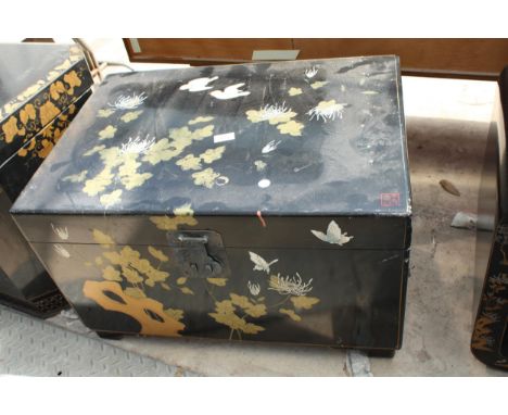 A BLACK LAQUER TRUNK WITH BRASS HANDLES AND CHINOISERIE DECORATION, 27" X 19" 