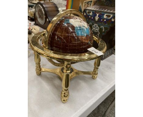 A GEMSTONE GLOBE WITH A COMPASS TO THE BASE 