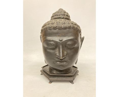 A LARGE BRASS BUDDHA HEAD WITH A BRONZE FINISH ON WOODEN STAND (POSSIBLY 1950'S) 