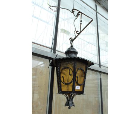 A VINTAGE WALL HANGING LANTERN WITH YELLOW GLASS CONVERTED TO ELECTRIC AND COMPLETE WITH HANGING BRACKET 