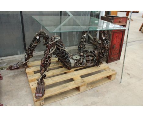 A GLASS TOPPED TABLE WITH SCRATCH BUILT MECHANIC TABLE BASE FORMED USING CAR PARTS AND TOOLS 