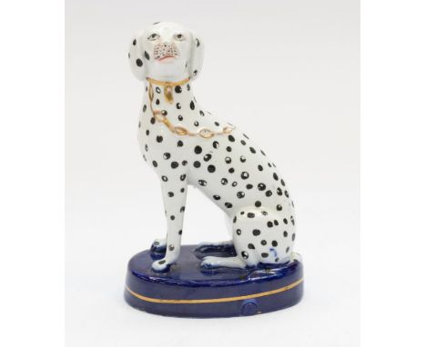 A Staffordshire model of a Dalmatian with a gilt collar and chain, seated on a cobalt blue base, C1860. height 13.5cm. A chip