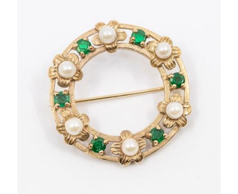 An emerald and pearl 9ct gold circular brooch, open form set with alternate round cut claw set emeralds and cultured pearls w